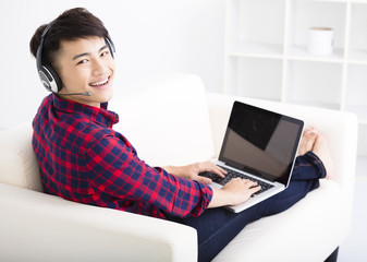 handsome young man using laptop computer with headset