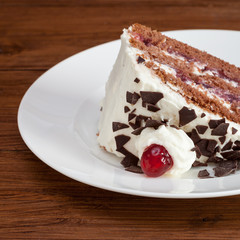 Ein Stück Schwarzwälder Kirschtorte, Holzhintergrund