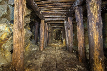 Fototapeta na wymiar Old abandoned gold mine tunnel passage with yellow sulfur dirt