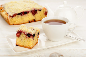 Sweet homemade cake with berries and cup of tea.