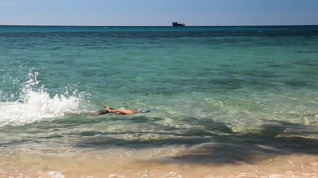 Man swim in crystal clear water of the sea