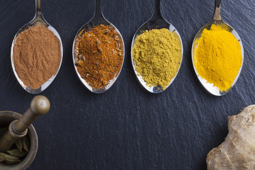 oriental indian spices curry paprika nutmeg on slate