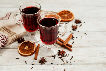 
mulled wine with oranges , honey , cinnamon and cloves on a wooden background   