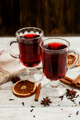 
mulled wine with oranges , honey , cinnamon and cloves on a wooden background   