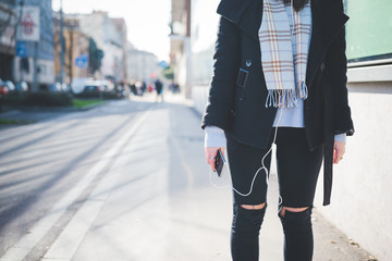 From the neck down view of young caucasian woman listening music