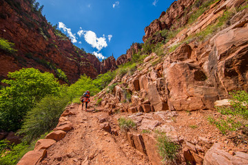 Traveler with big backpack among the rocks of the canyon. North Kaibab trail, Grand Canyon, North Rim