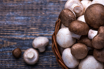 Mushrooms in a basket on a wooden table background.