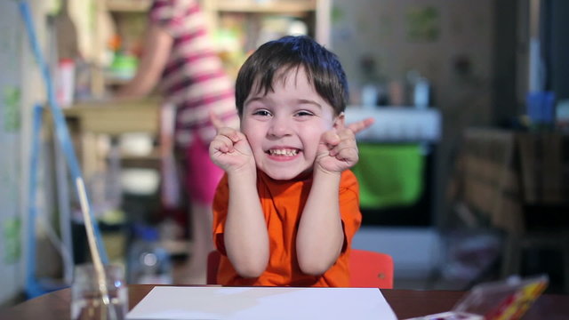 Joyful child at the table with a brush