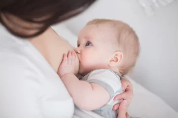 Fototapeten mother breast feeding and hugging baby © uv_group
