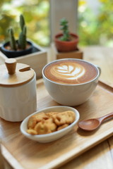 hot latte art  with cactus in coffee shop on table wooden