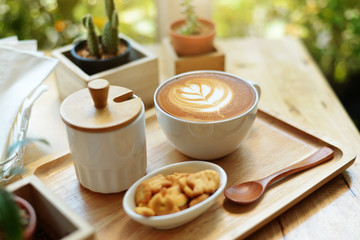 hot latte art  with cactus in coffee shop on table wooden