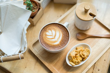 hot latte art  with cactus in coffee shop on table wooden