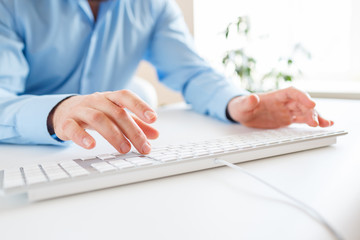 Fototapeta premium Man office worker typing on the keyboard