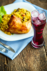 Tasty dishes from chicken thigh with rice and lettuce and a glas