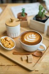 hot latte art  with cactus in coffee shop on table wooden
