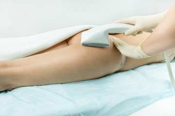 Obraz premium Woman patient having Vacuum roller massage thighs and buttocks. Slender body shaping. correction body shape. Weight loss and anti-cellulite programs. Massage cabinet in the professional beauty clinic