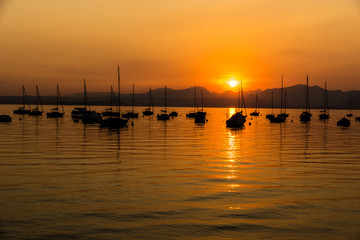 Fototapeta premium Sailing Boats on lake Garda with sunset, Italy