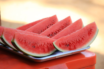 Fresh slice of watermelon on a stainless steel tray ,outdoors in the sunshine