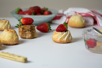 mini vanilla cakes decorated with strawberries in season