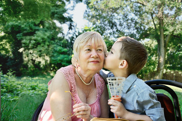 Fototapeta premium grandson hugs and kisses on the cheek his grandmother