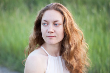 woman with long red curly hair and blue eyes