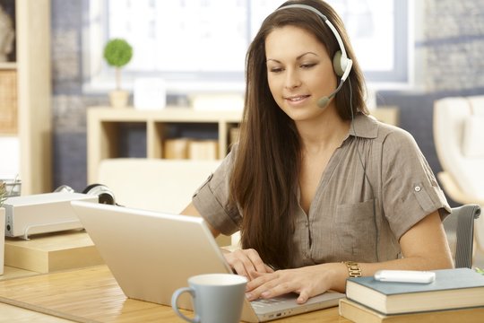 Young woman with laptop and headset