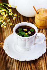 tea with a chamomile and herbs in a white mug