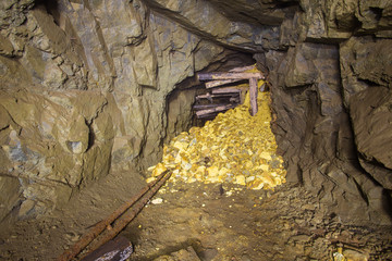 Old abandoned gold mine tunnel passage with gold ore