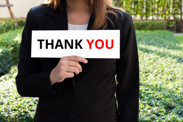 Businesswoman showing white sign with thank you word.