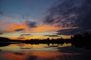 Fototapeta na wymiar Dramatic evening sky over lake, tranquil nature scene