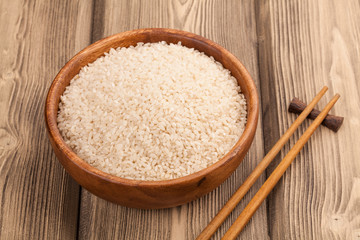A wooden bowl of grain white rice chopstick