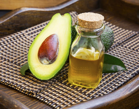 Avocado oil in bottle with avocado fruit