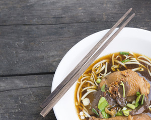 Thai style chicken noodle with soup on the vintage woodden background