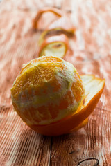 A peeled orange on the wooden background