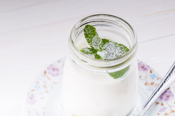 Open glass jar of yogurt
