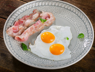 Two Fried eggs with bacon slices for breakfast.