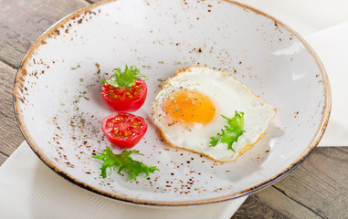 Fried egg with fresh vegetables for breakfast.