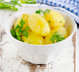 Boiled potatoes in white bowl.