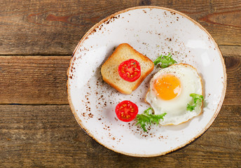 Breakfast with egg, toast and fresh tomatoes.