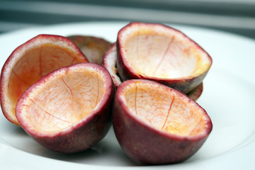 Passion fruit half cut empty inside on white dish