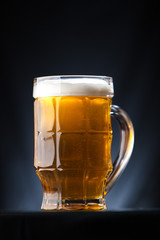 Big glass of beer over a dark background