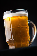 Big glass of beer over a dark background