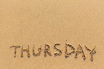Thursday - word drawn on the sand beach.