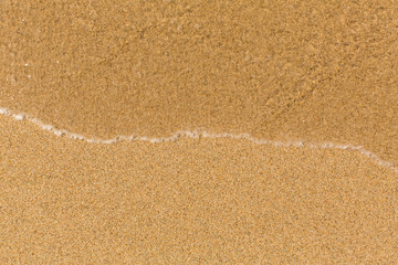 Texture sand beach with soft waves.