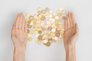 Money and Finance Topic: Money coins and human hand showing gesture on a gray background in studio top view