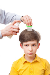 Man sprinklers child head by anti-nits spray