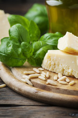 Basil, cheese, pine and olive oil on the wooden table