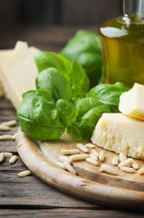 Basil, cheese, pine and olive oil on the wooden table