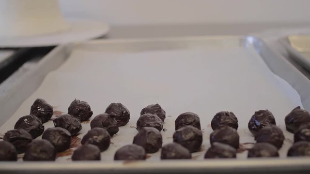 Chocolate mousse truffles being placed onto a cookie sheet