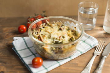 Tomato gratin with cheese and zucchini in baking dish